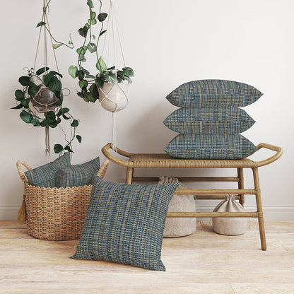 Boho living scene: light rattan bench with blue solid fabric cushions, wicker basket with extra cushions, and hanging potted plants.