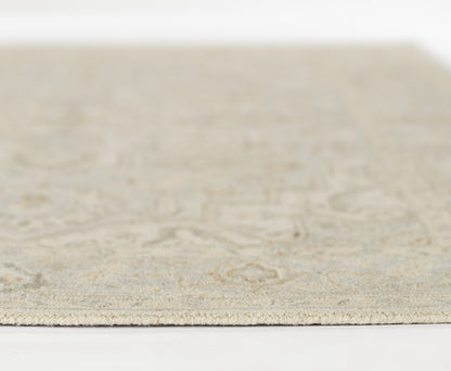 Beige/cream textured area rug with a subtle intricate pattern; low-pile, rectangular rug for living room or bedroom.