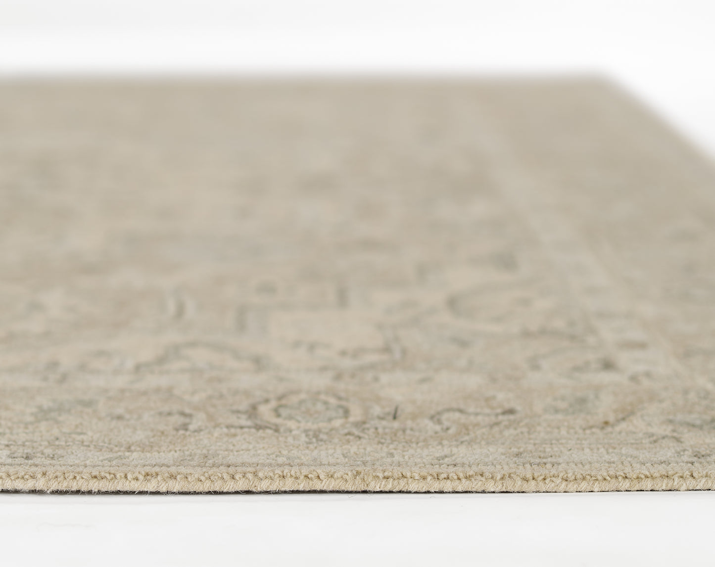 Taupe flat-weave rug close-up edge, subtle geometric pattern and natural fiber texture for neutral decor.