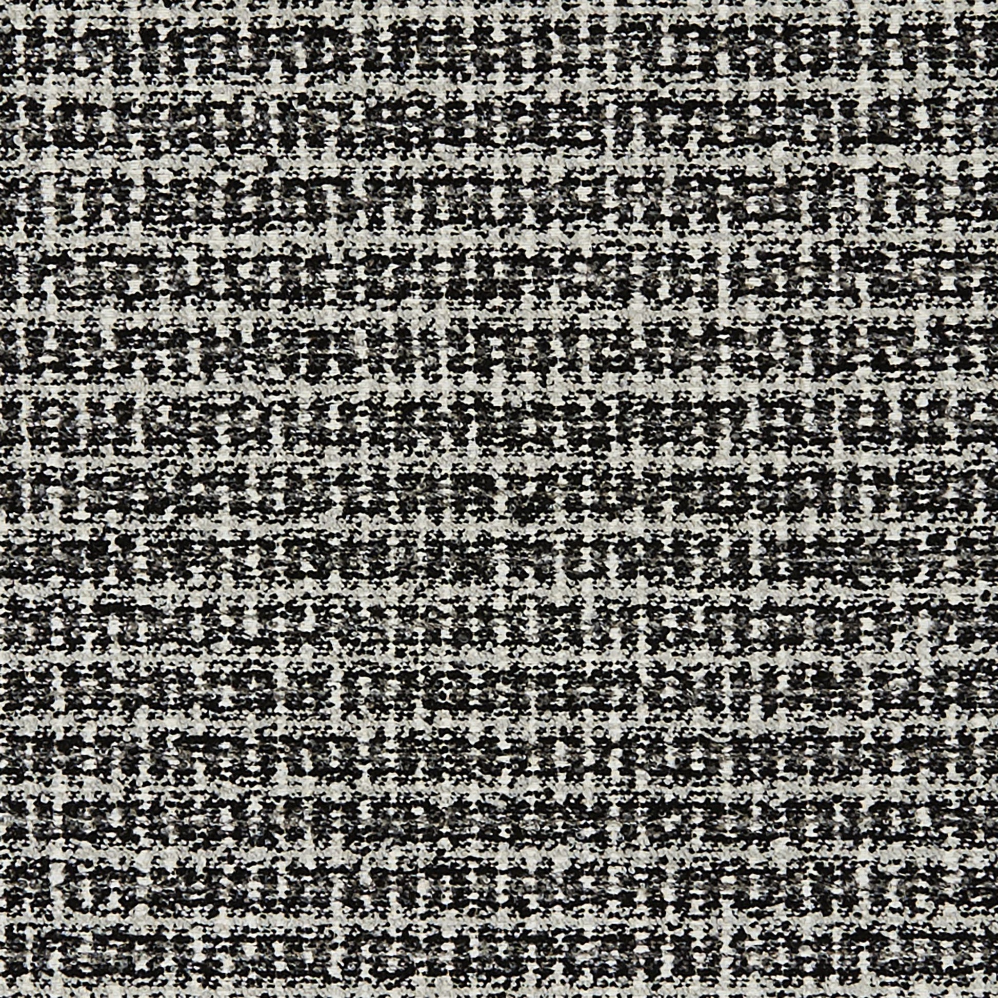 Close-up of black & white boucle jacquard fabric with a speckled gray weave; textured textile.