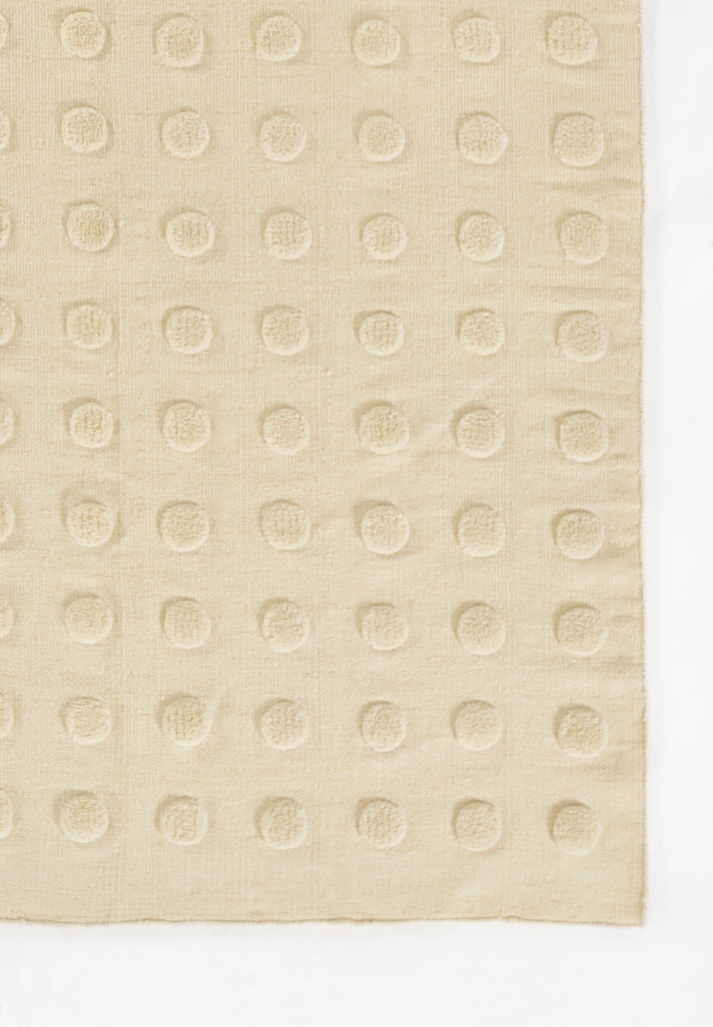 Beige rug with embossed circular dot grid; subtle cotton/linen texture; size 5' x 8'.