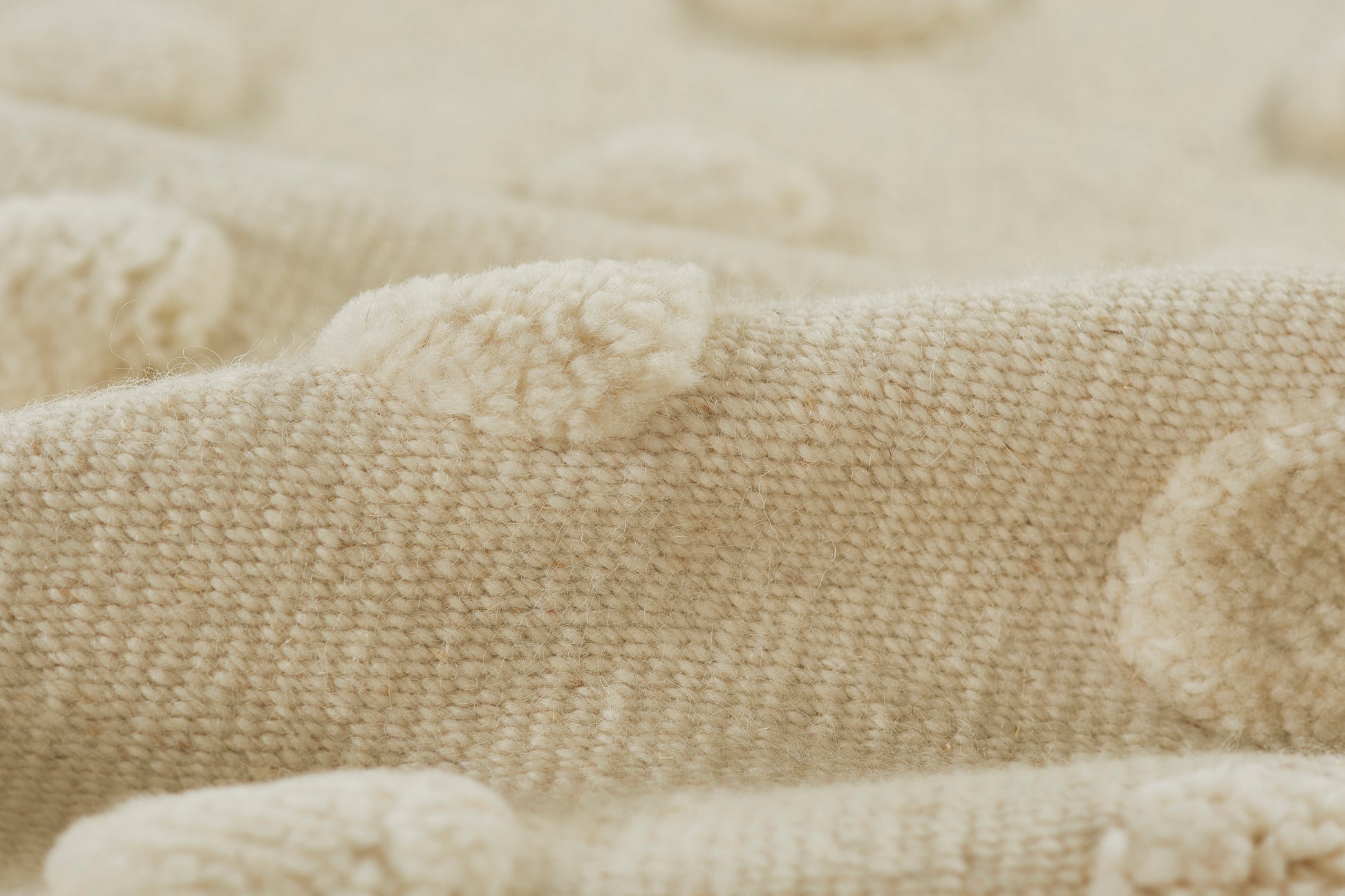 Cream-beige knitted rug with plush pom-poms, soft textured cozy area rug, 5' x 8'.