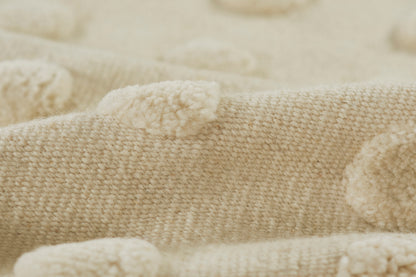 Cream-beige knitted rug with plush pom-poms, soft textured cozy area rug, 5' x 8'.