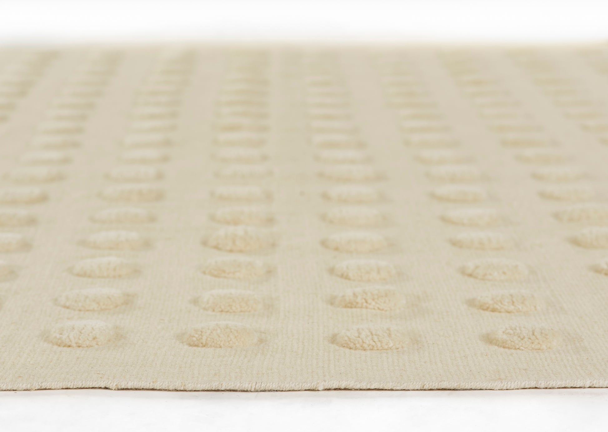 Beige rug with repeating tan circular dot pattern; flat, low-pile weave for modern living room decor.