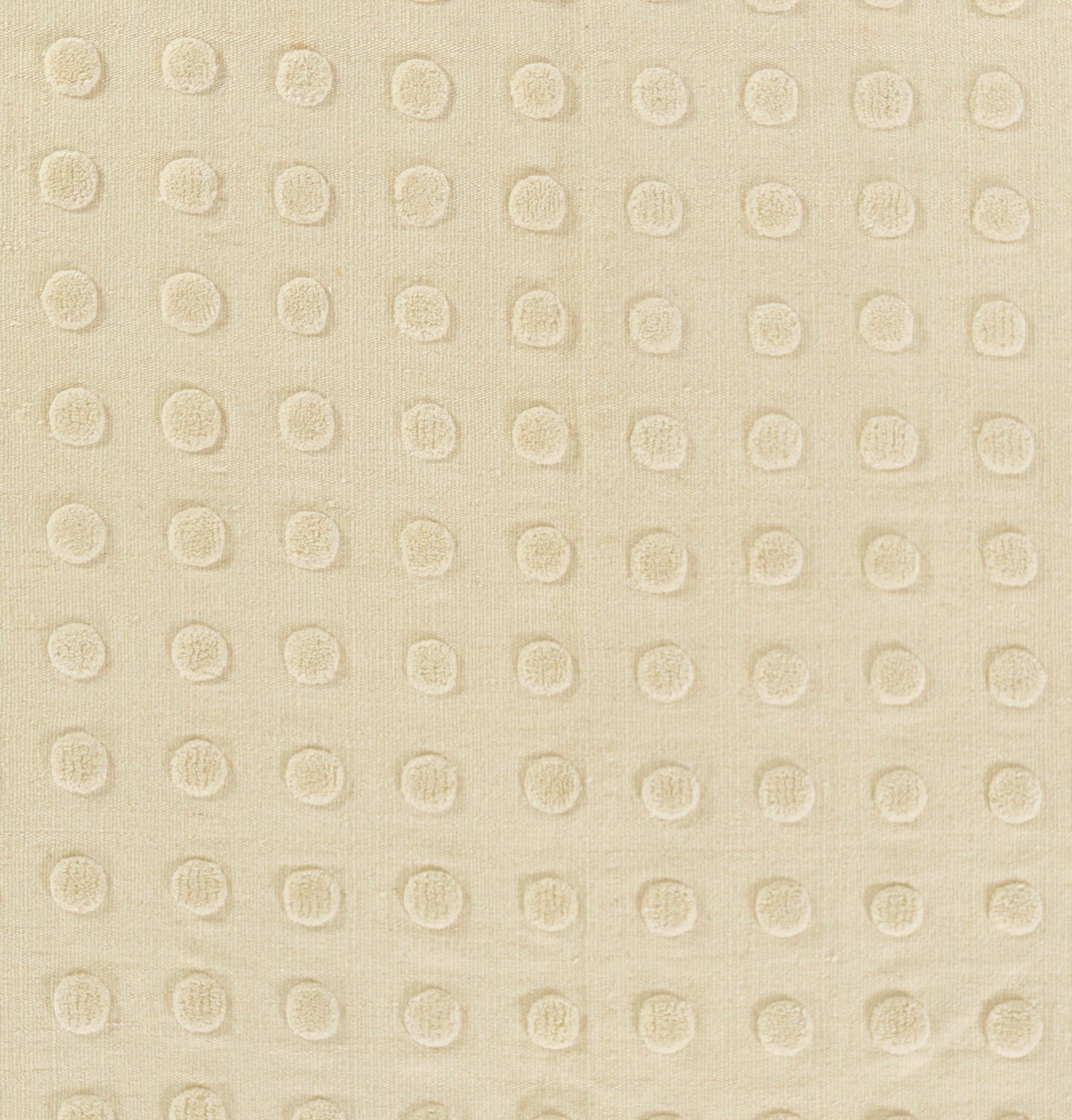 Beige rug with raised circular dot pattern in a regular grid; tactile textured weave.