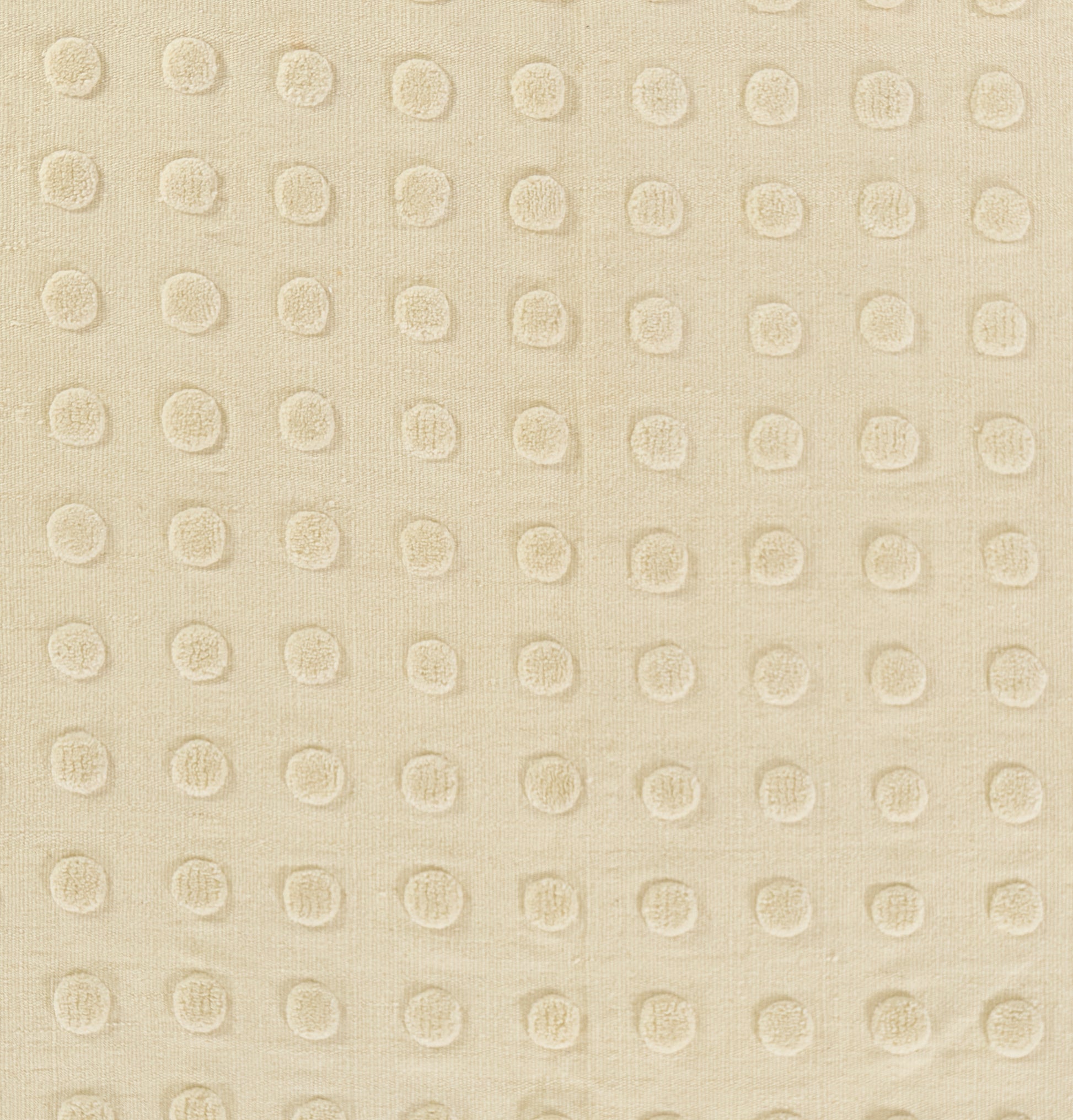 Beige rug with raised circular dot pattern in a regular grid; tactile textured weave.