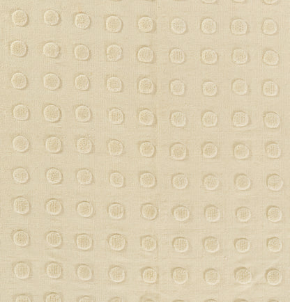 Beige rug with raised circular dot pattern in a regular grid; tactile textured weave.