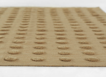Taupe natural-fiber mat with evenly spaced circular tufted dots; modern entryway/kitchen rug.