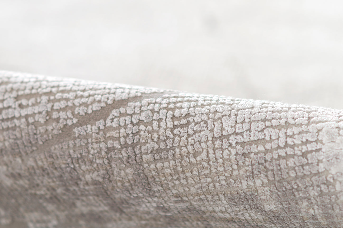 Gray crackle-textured fabric with a subtle raised pattern, ideal for upholstery or decor.