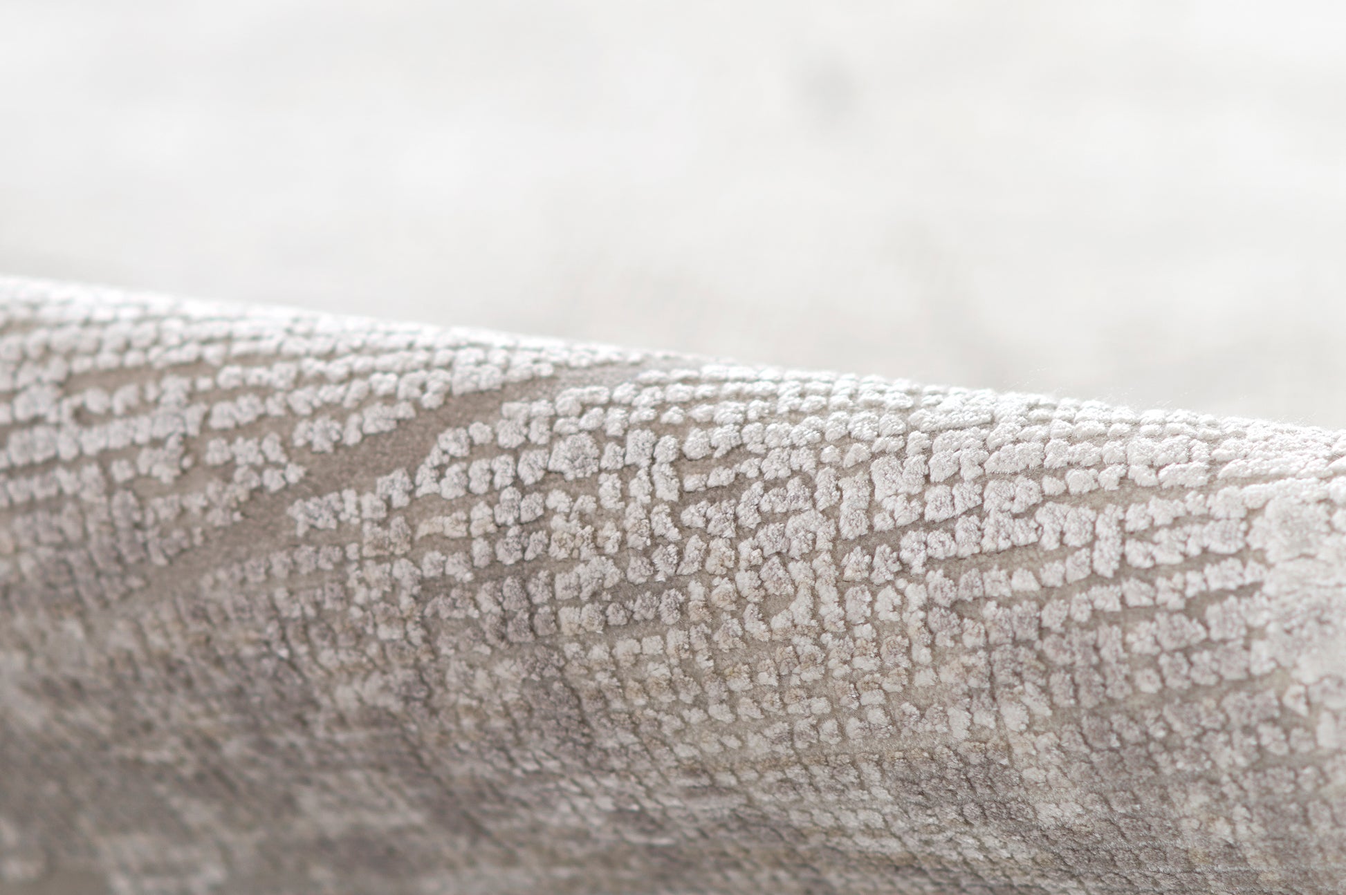 Gray crackle-textured fabric with a subtle raised pattern, ideal for upholstery or decor.