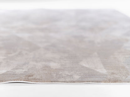 Light gray textured woven rug with subtle pattern; close-up edge, neutral home decor.