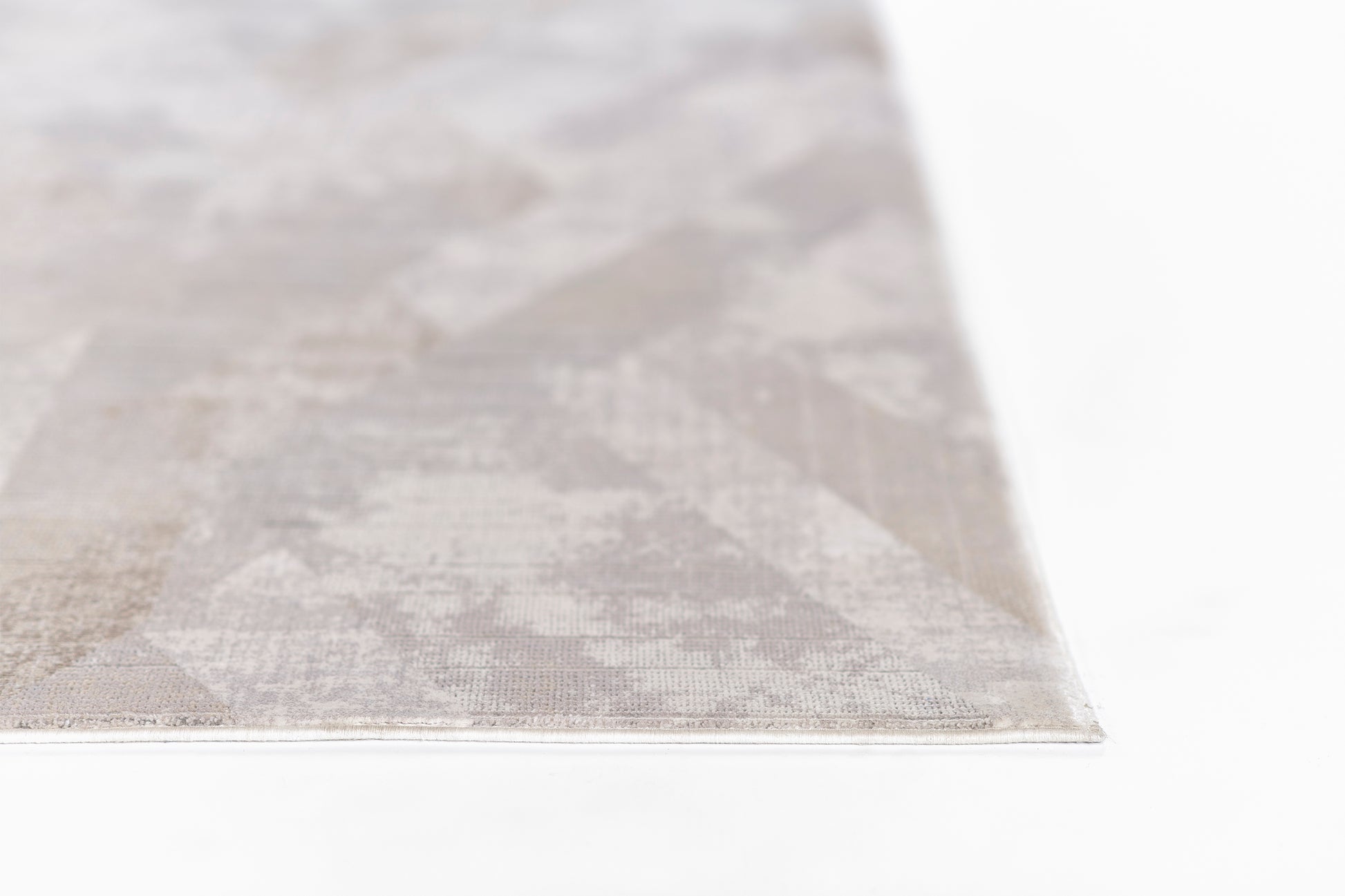 Close-up of a rectangular grey rug with a subtle geometric pattern and woven texture.