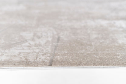 Close-up of a gray-beige woven rug with a subtle pattern and a light border.