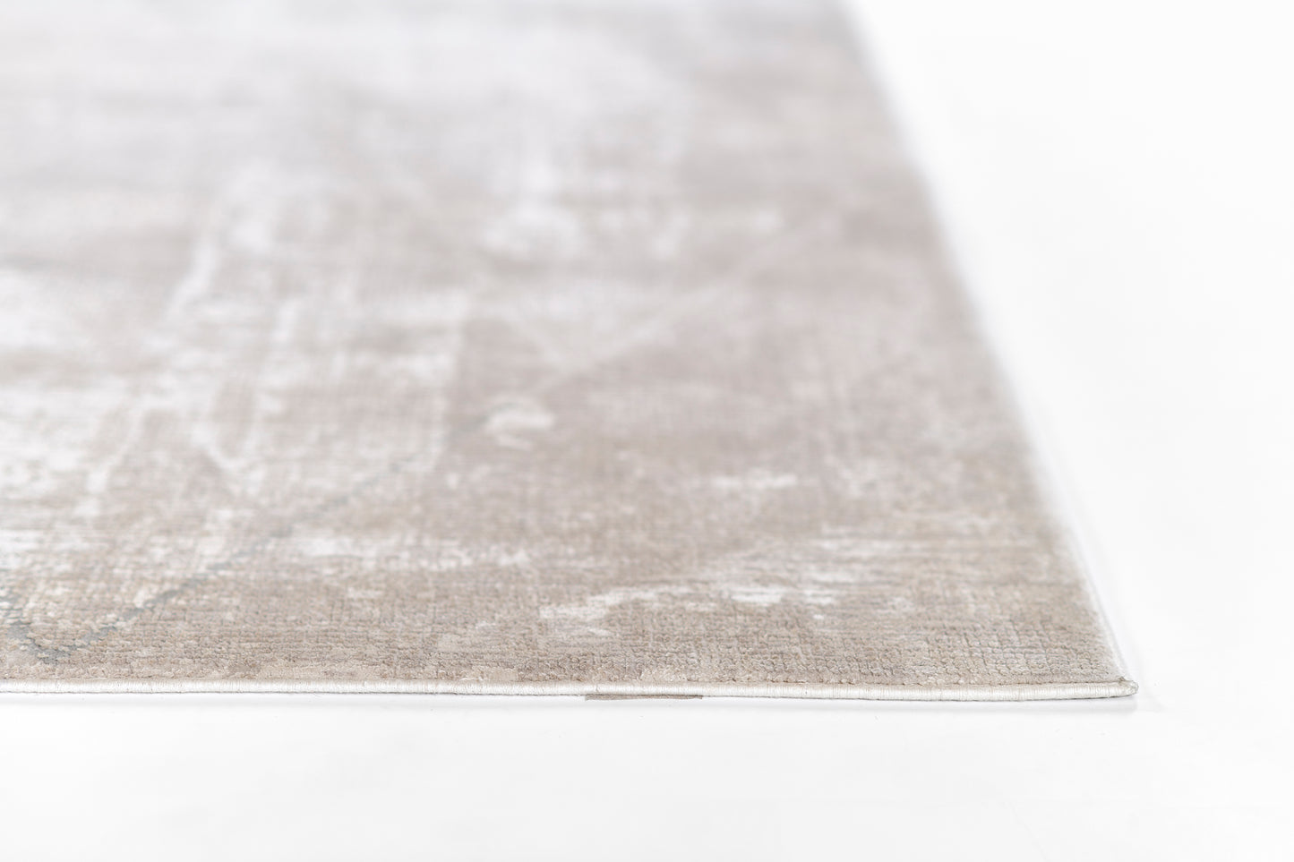 Light gray textured area rug with white distressed pattern, low-pile, rectangular edge visible.