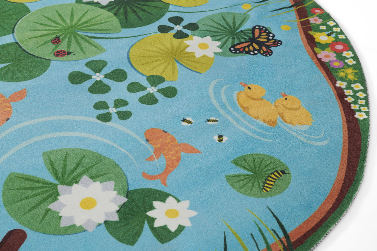 Blue rug with pond-scene design: lily pads, water lilies, orange fish, yellow ducklings, butterfly, bee, and floral border.