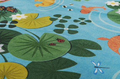 Blue kids play mat with green and yellow lily pads, orange fish, and dragonflies; soft textile rug for playroom decor.