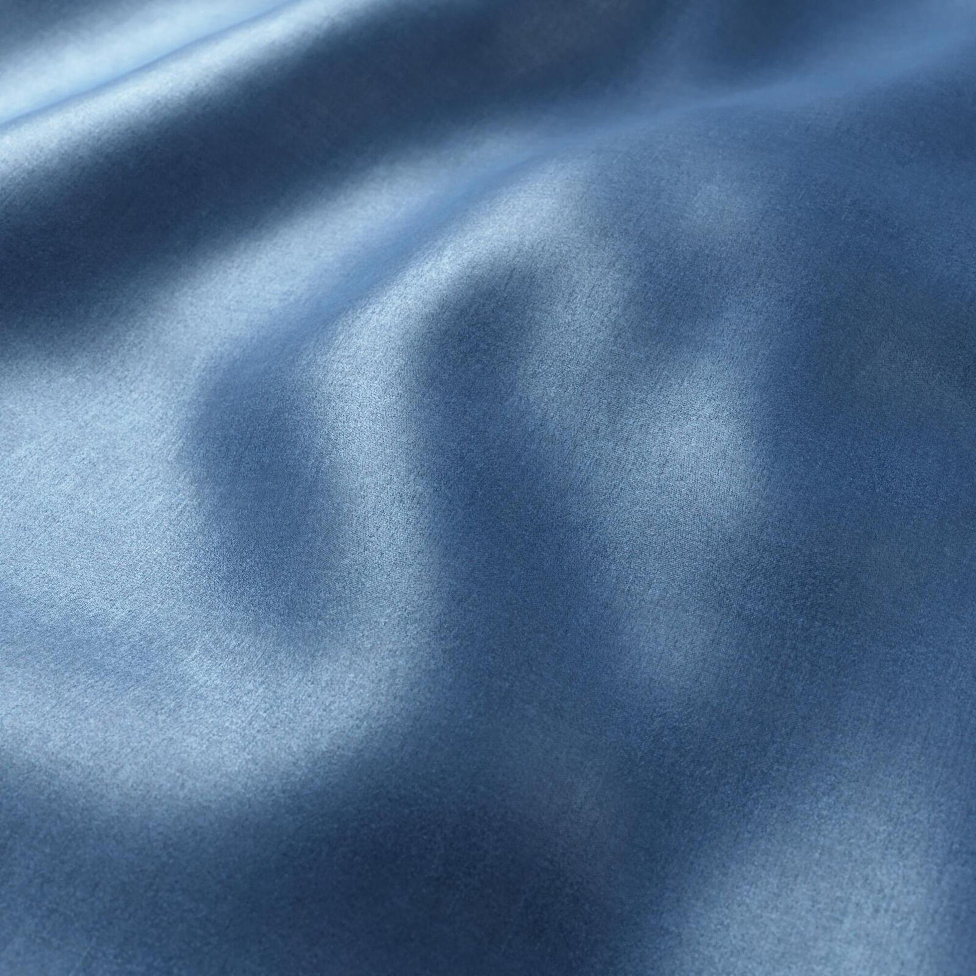 Blue sateen fabric with soft folds and subtle sheen, polished smooth textile.