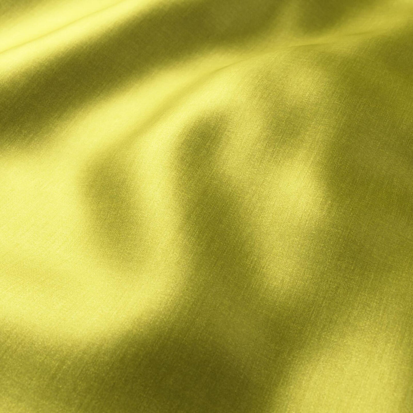 Close-up of polished lime-yellow sateen fabric with soft folds and sheen.