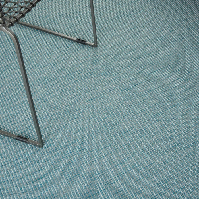 8x10 aqua blue indoor outdoor area rug from the Positano collection by Nourison featuring a modern solid design with subtle woven texture. Durable polypropylene machine-made rug designed for patios, decks, porches, living rooms, bedrooms, and dining rooms. Lightweight, stain-resistant, and easy-clean rug ideal for high-traffic areas and homes with pets or kids. Modern coastal rug perfect for contemporary, minimalist, and boho home decor.