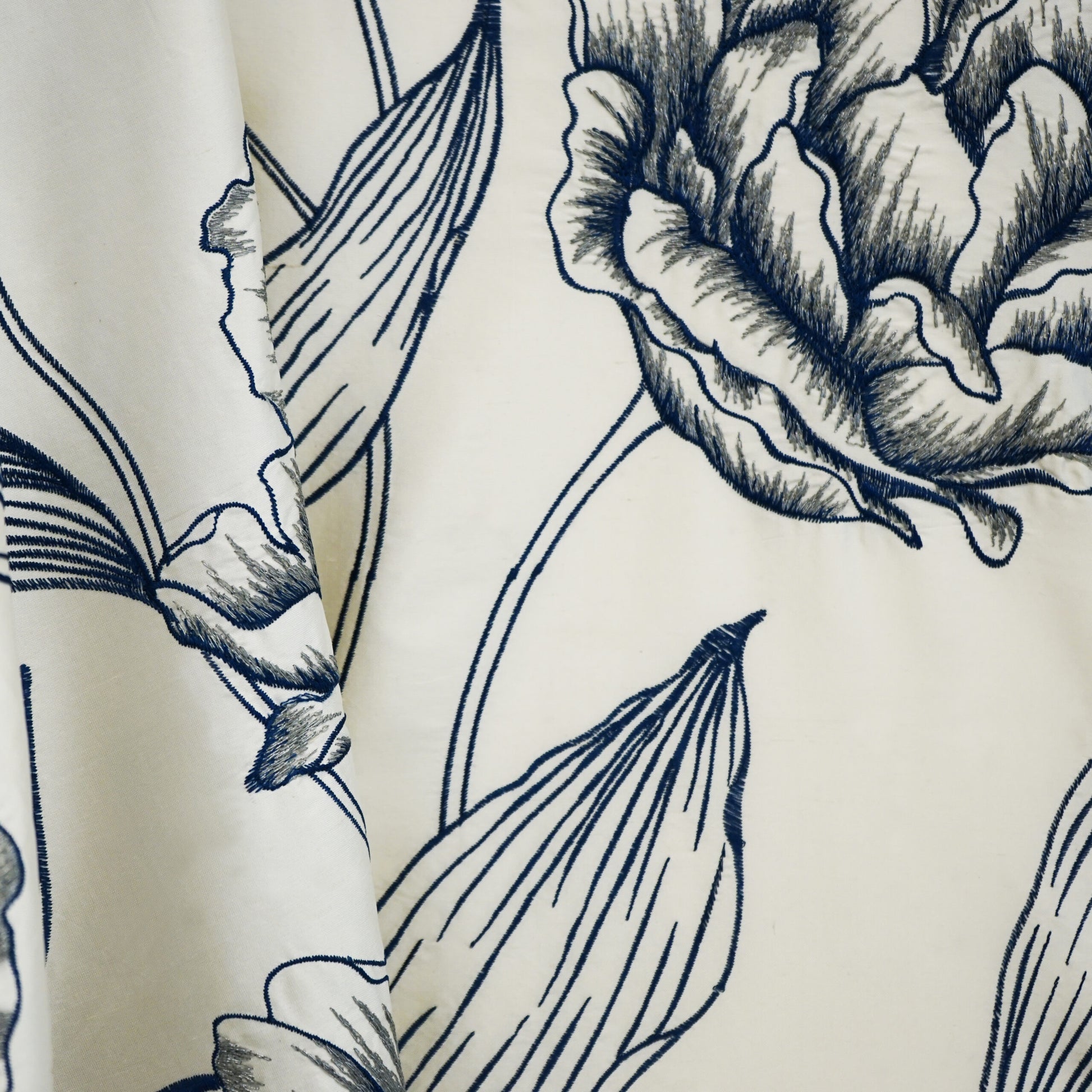 Cream fabric with navy blue primrose floral line art; large blooms and leaves, botanical print for apparel or decor.