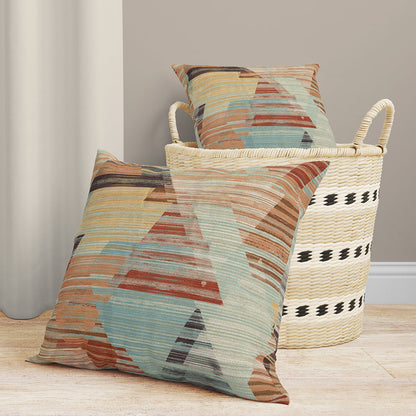 Geometric prism print fabric in teal, rust, tan & blue; woven textile with angular shapes shown draped over a wicker basket.