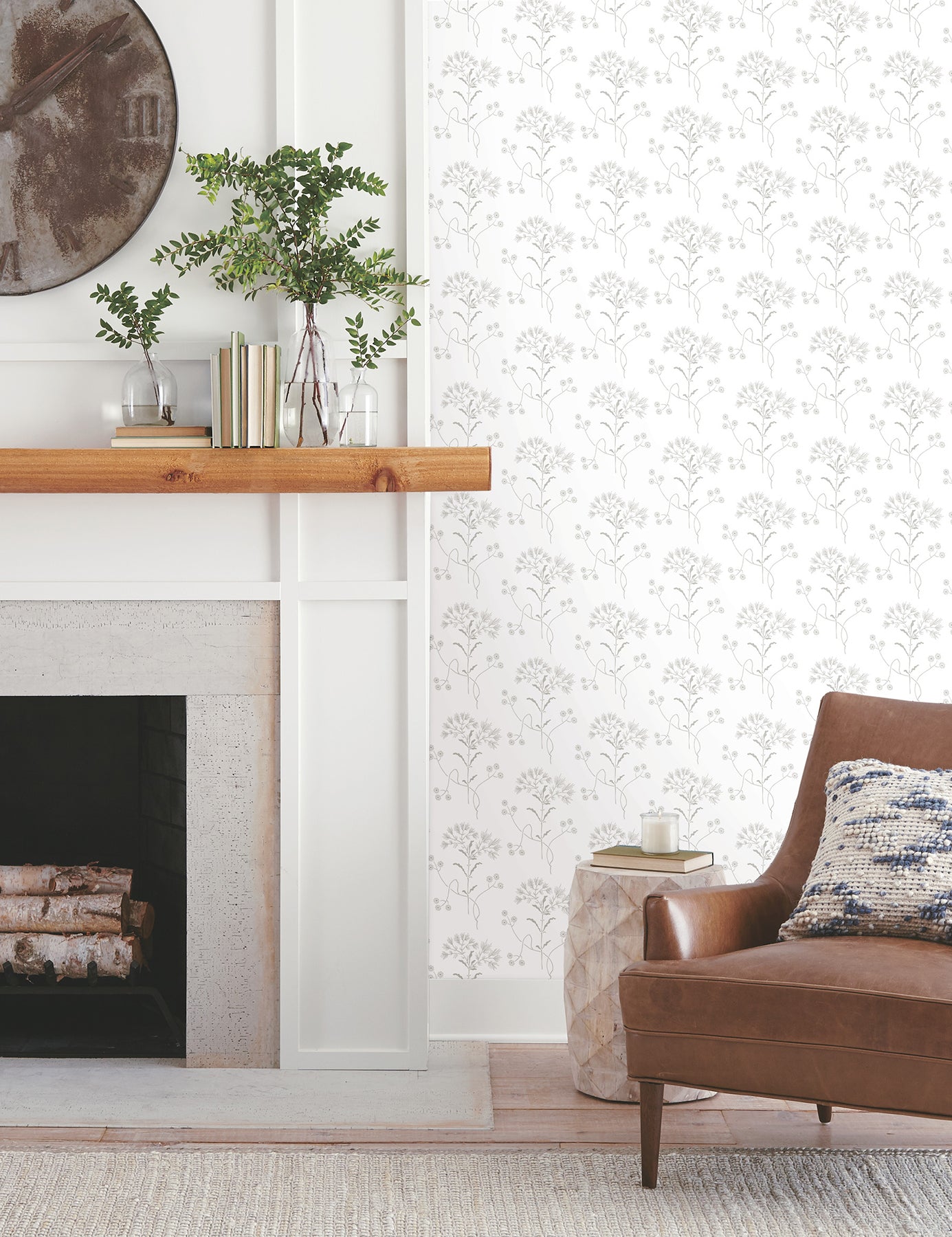Room interior featuring grey floral wallpaper with wildflowers on the walls, white paneling, greenery, and a brown leather chair.