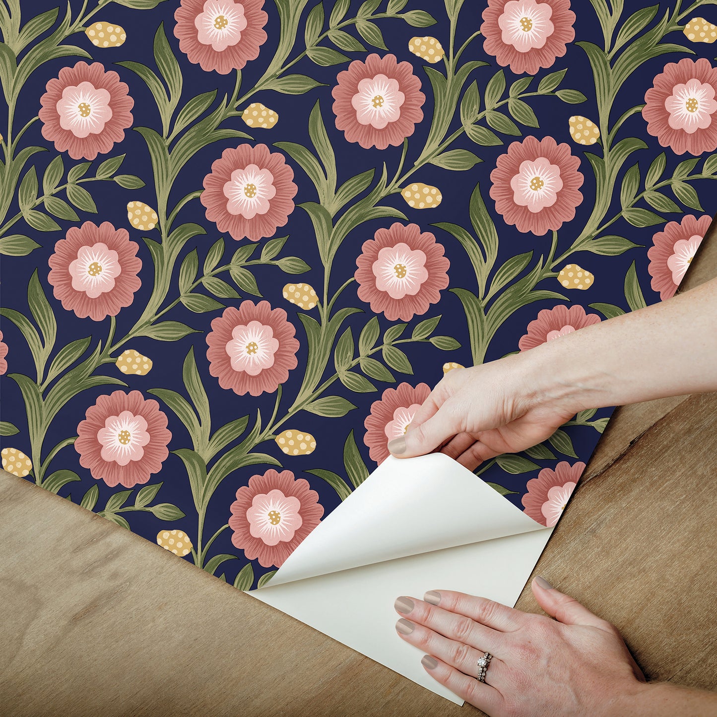 Lillian Blue Floral Vine peel and stick wallpaper by Mirth Studios — rich deep blue background with leafy green vines and pink blooms, non‑woven removable self‑adhesive wallcovering roll, ideal for accent walls in living room, bedroom or nursery.