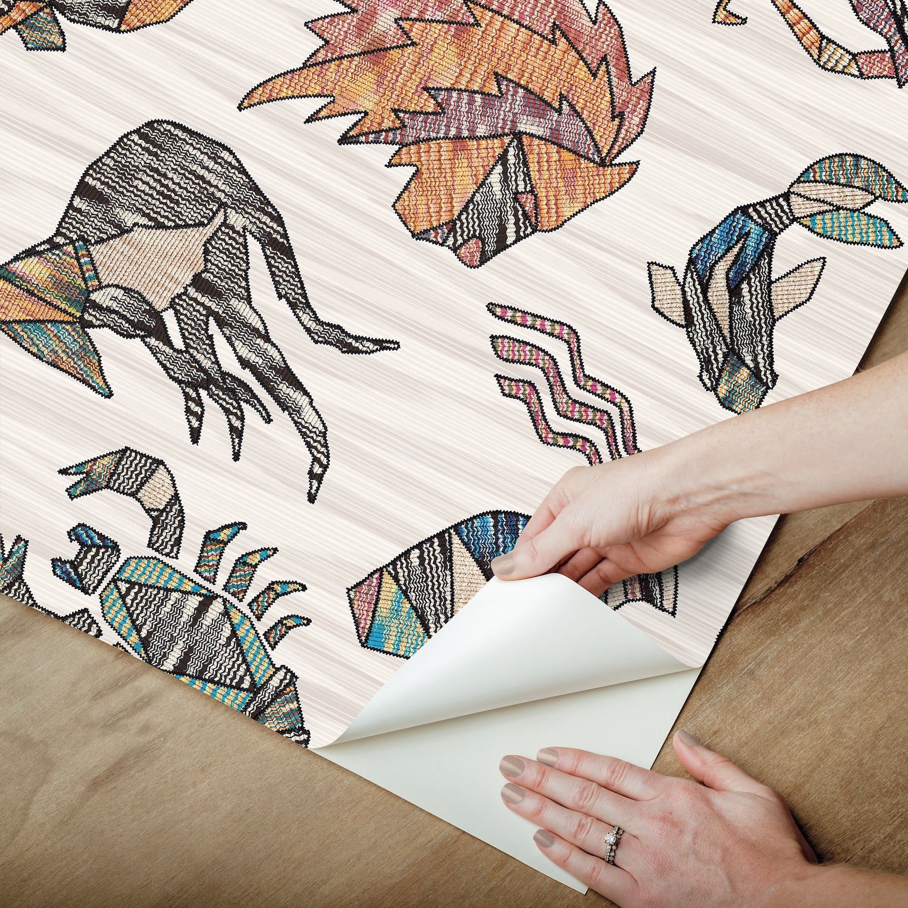 Peel-and-stick wallpaper in multicolor featuring zodiac motifs over flame-stitch background, Missoni PSWP Constellations pattern PSW1644RL.