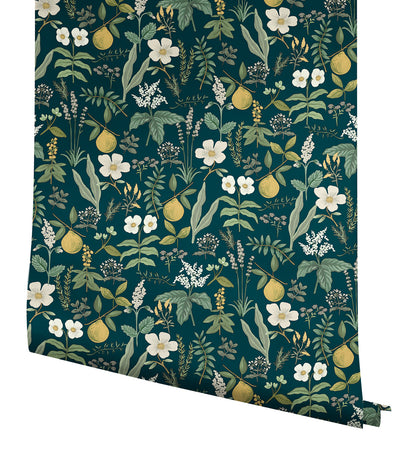 Dark teal wallpaper with botanical print featuring white flowers, yellow pears, & green leaves, rolled panel.