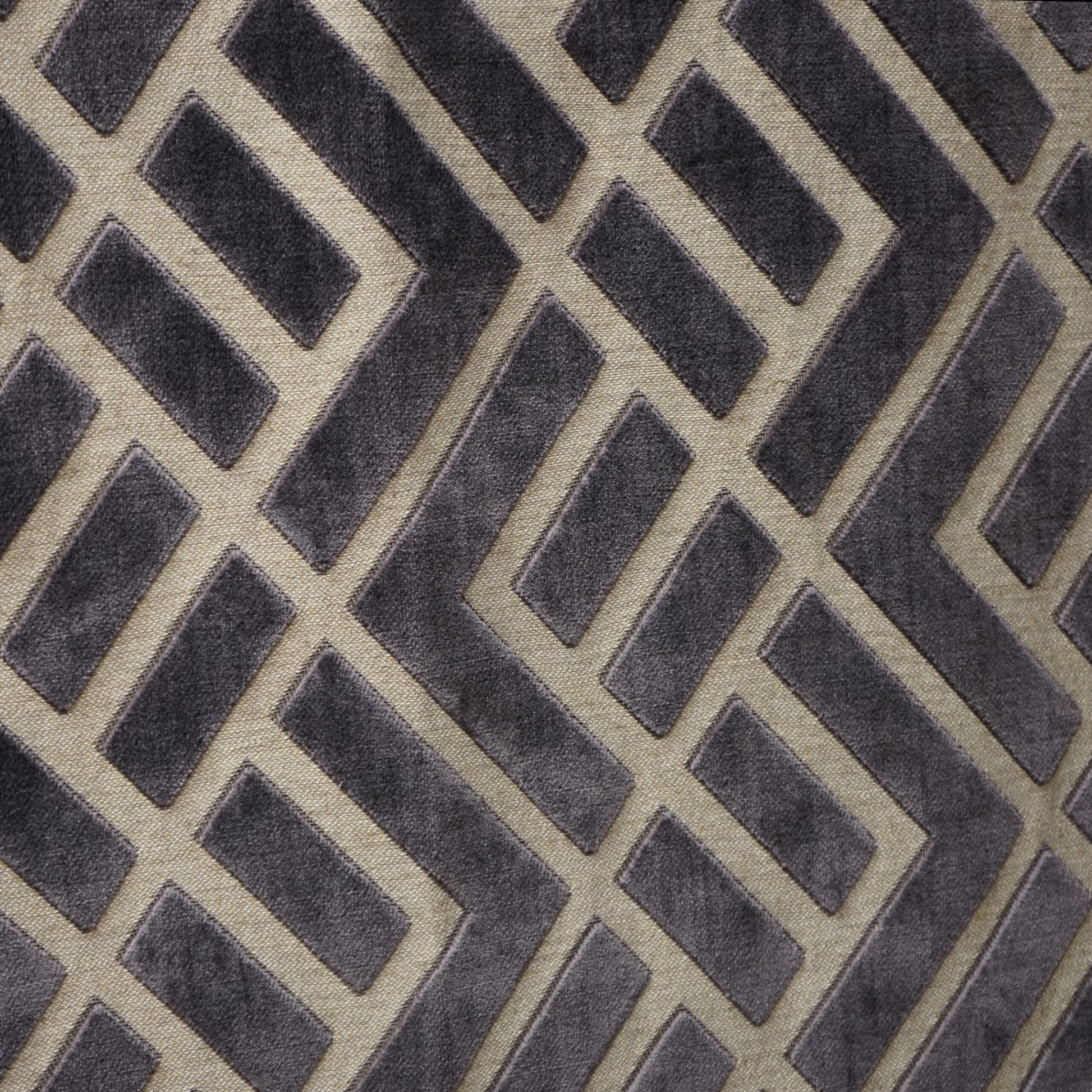 Velvet jacquard fabric swatch with an interlocking geometric lattice pattern in charcoal, creme, beige and grey.
