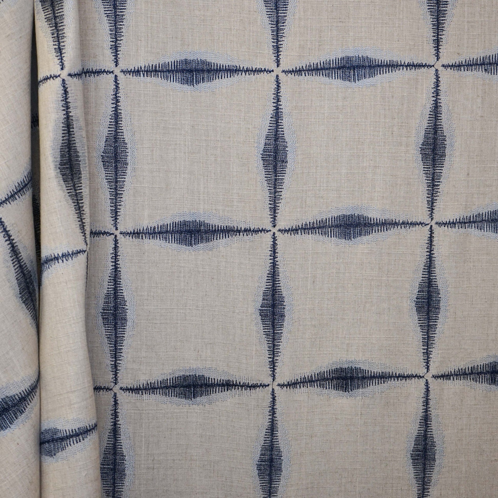 Beige linen fabric with navy geometric diamond quadrant pattern; lightweight, versatile upholstery or drapery material.