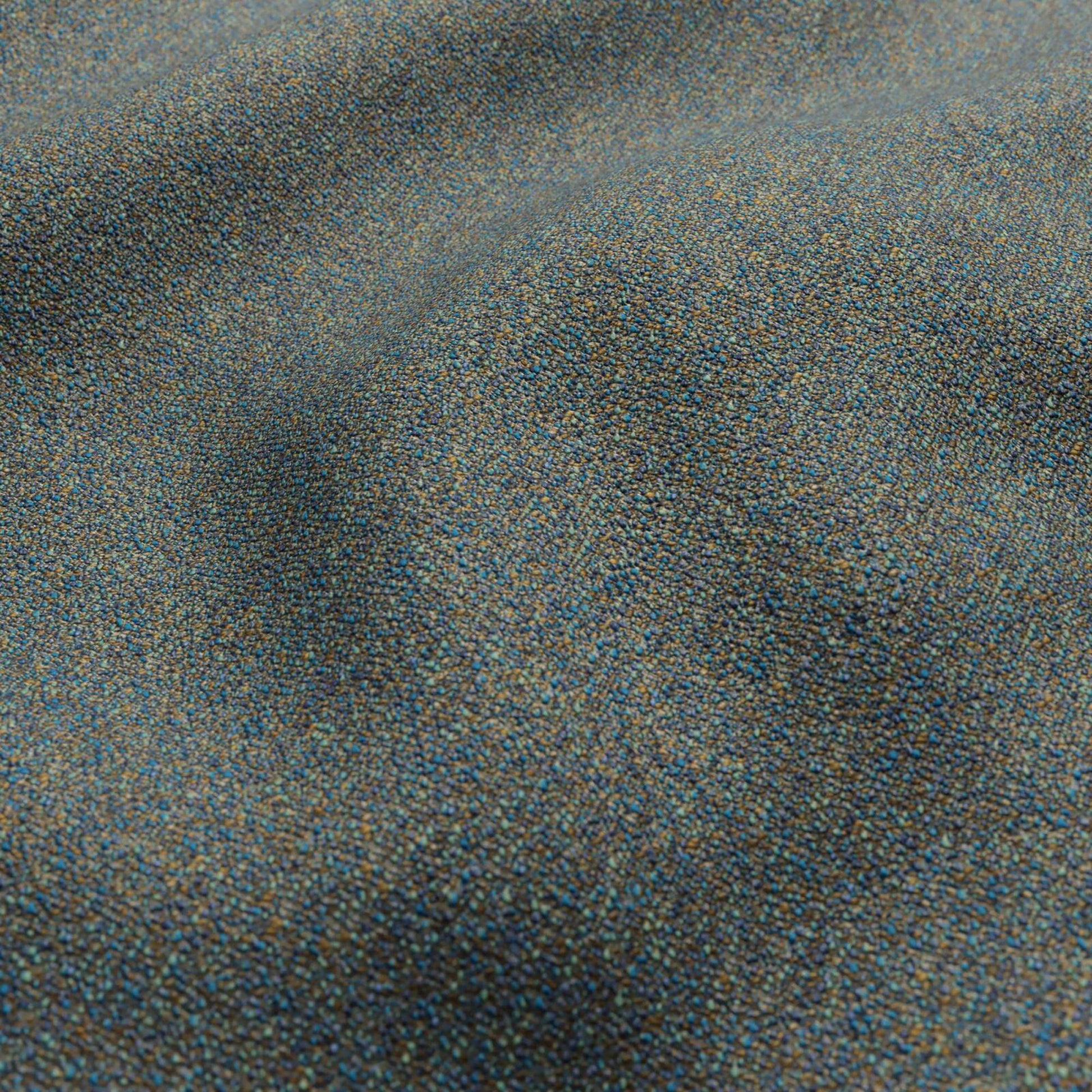 Close-up of blue-gray speckled boucle fabric with tiny multicolor specks.