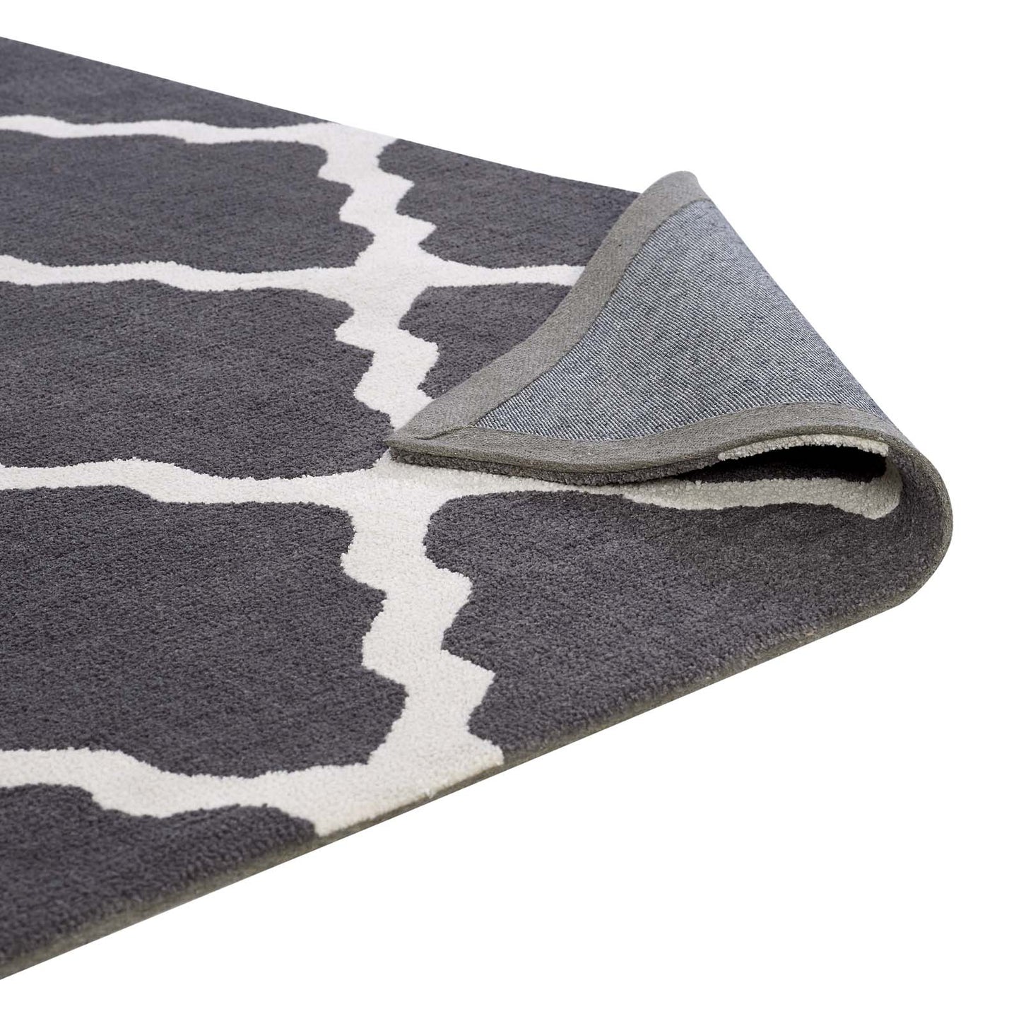 Grey rug with white trellis pattern, plush pile; folded corner reveals lighter underside.