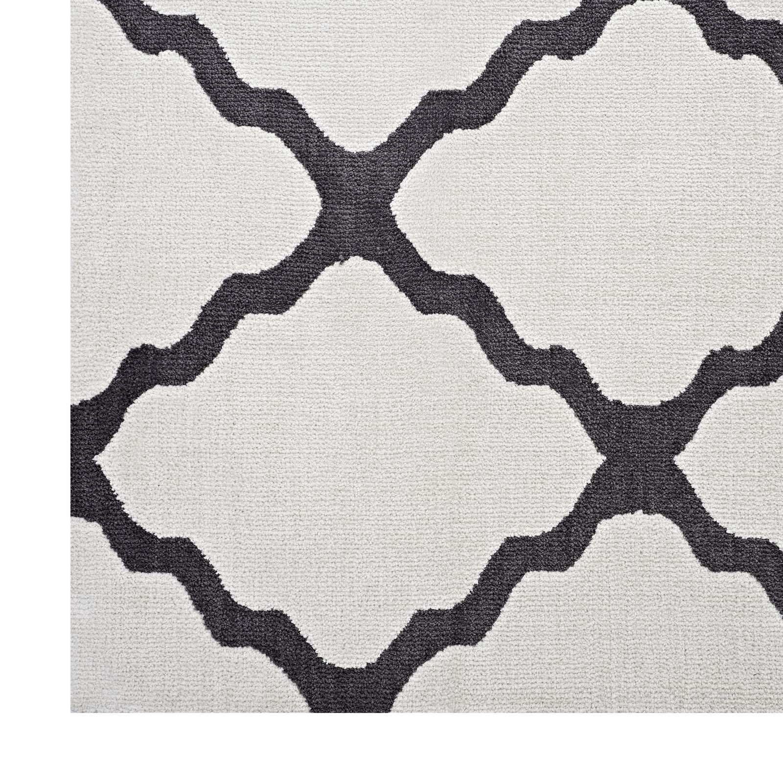 Beige textured rug with dark gray interlocking lattice quatrefoil pattern; modern geometric style.