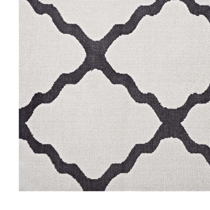 Beige textured rug with dark gray interlocking lattice quatrefoil pattern; modern geometric style.