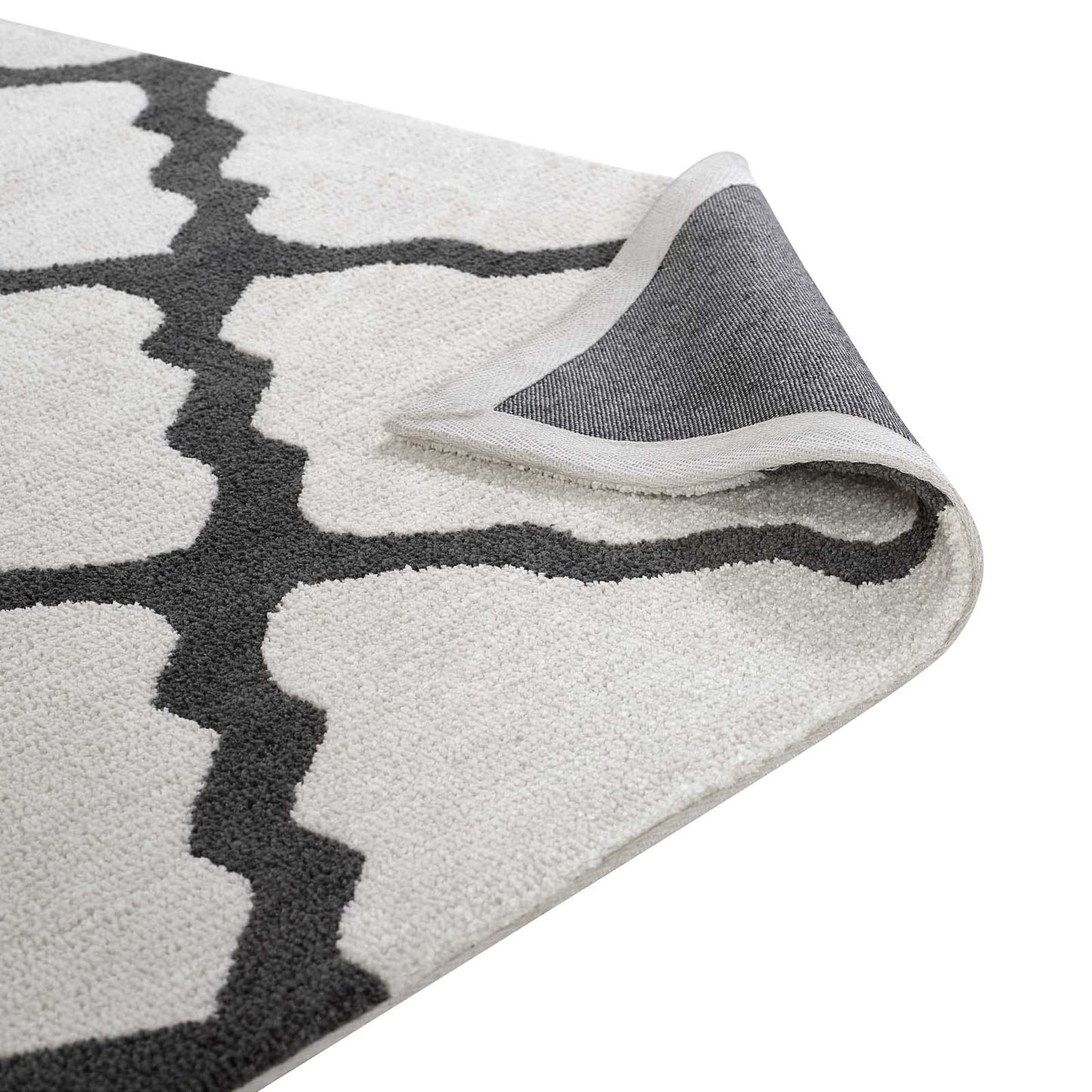 Cream rug with dark gray geometric trellis pattern; soft looped pile and light-gray backing shown at corner.