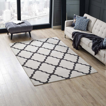Beige area rug with dark gray lattice trellis on light wood floor; living room with tufted sofa and navy accents.