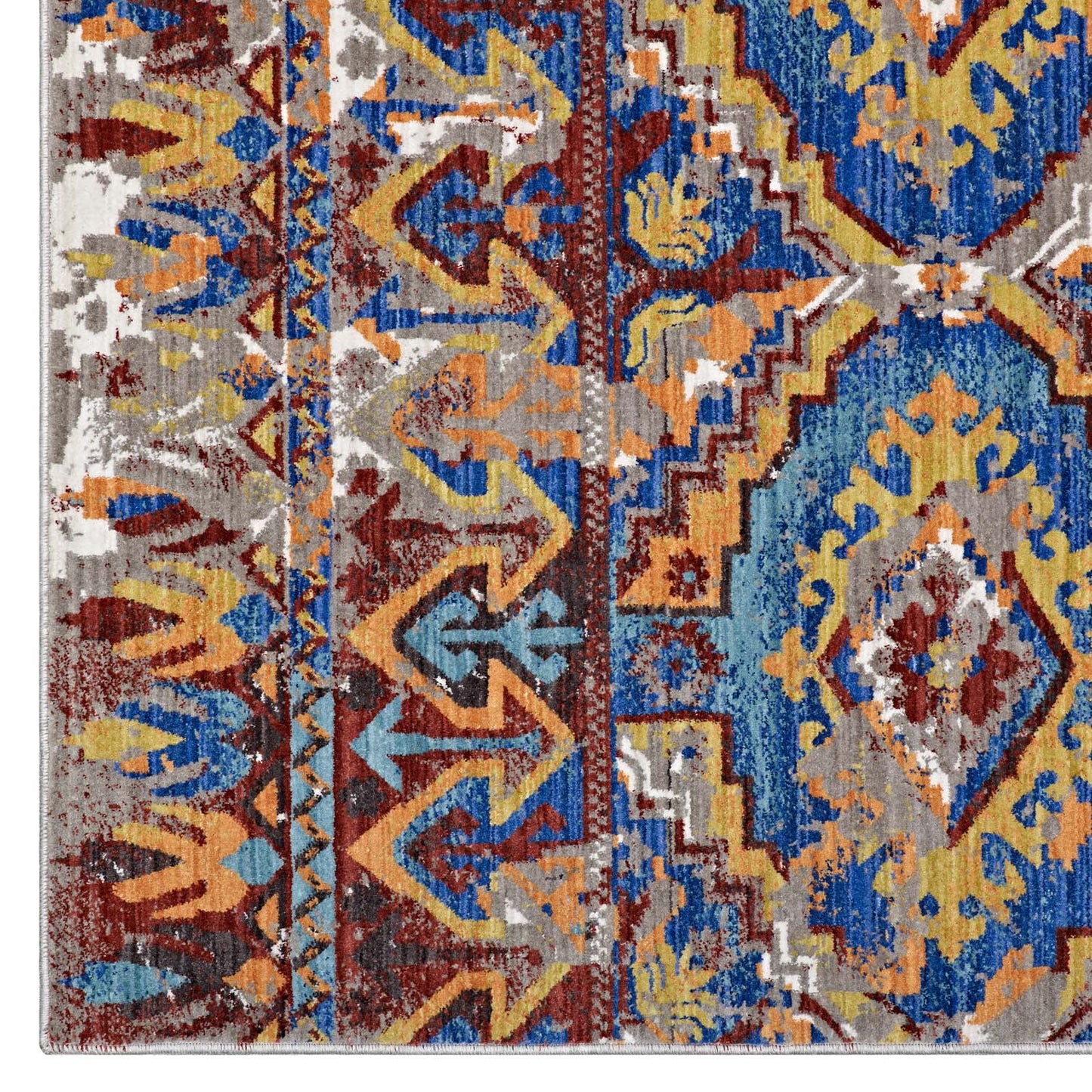 Distressed Southwestern Aztec rug with geometric blue, yellow, orange and burgundy motifs and cream accents.