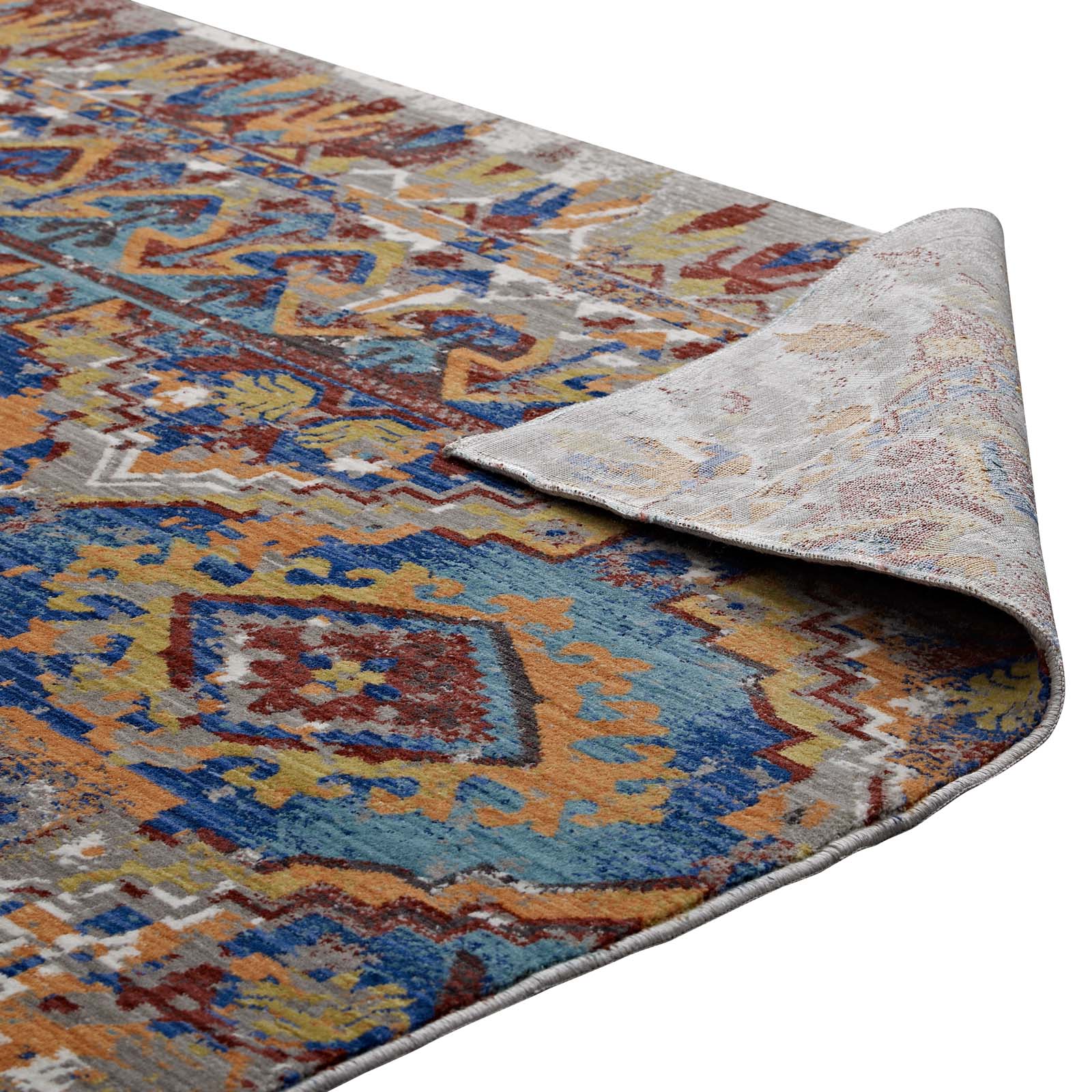 Colorful Southwestern Aztec-inspired area rug in blues, oranges and yellows; rolled corner reveals light gray backing; 8x10 ft.