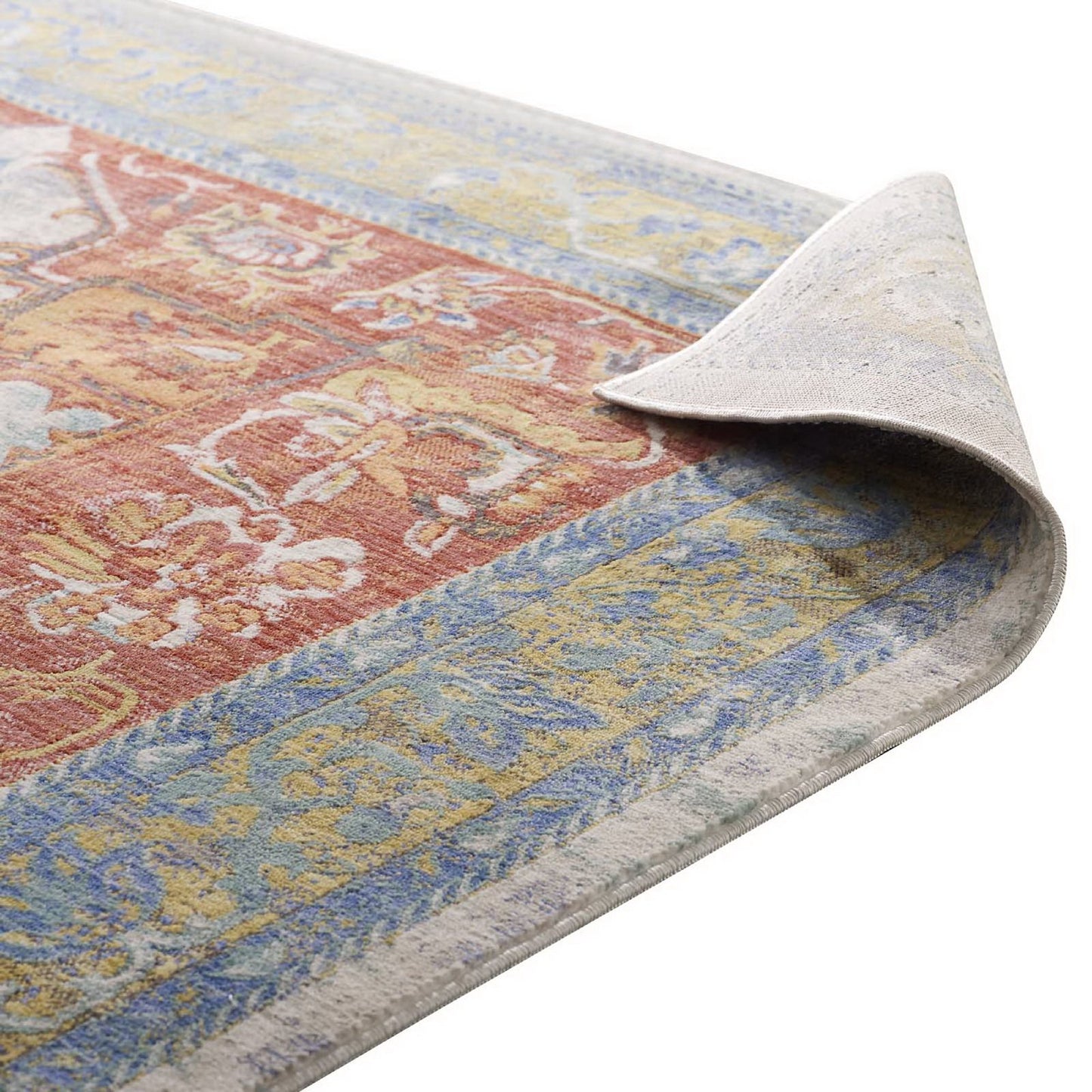 Vintage-style area rug with red central floral design and blue-gold borders; folded corner shows light backing.