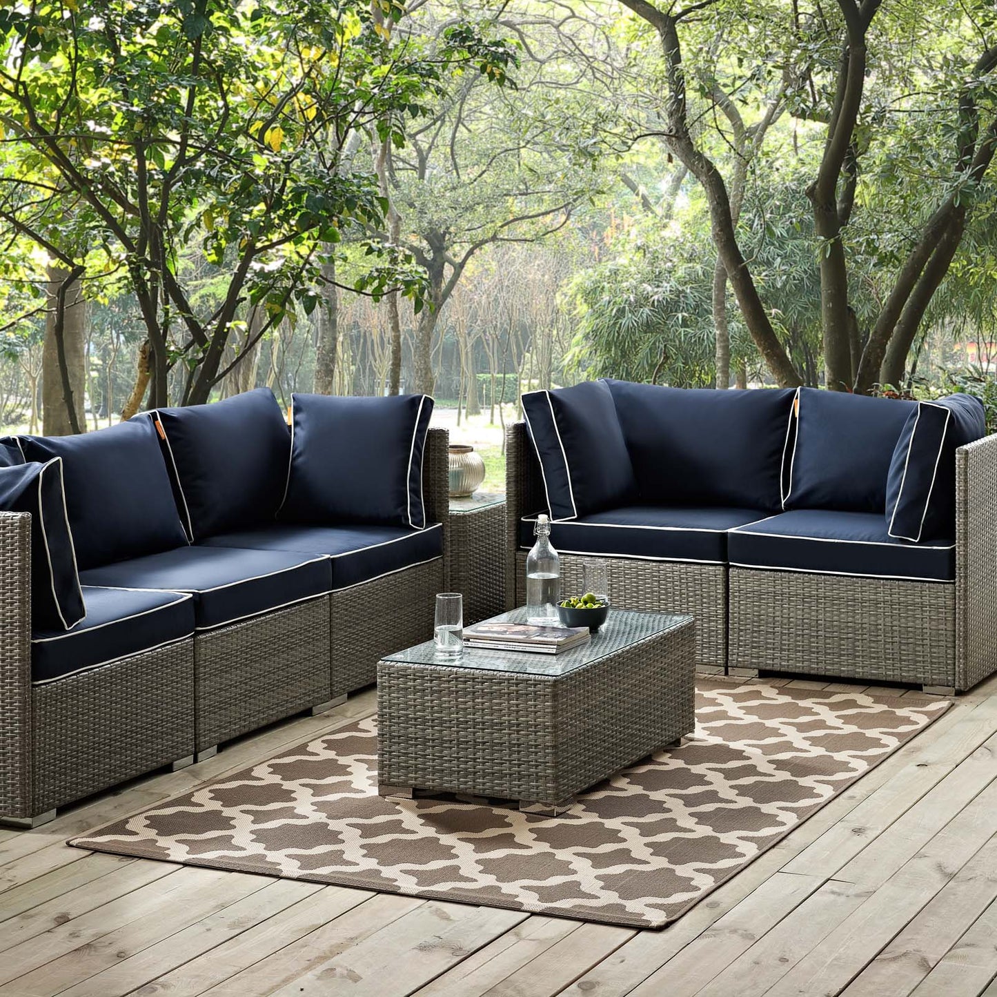 Light and dark beige Moroccan trellis 5x8 area rug for indoor or outdoor use, shown on a wooden deck.
