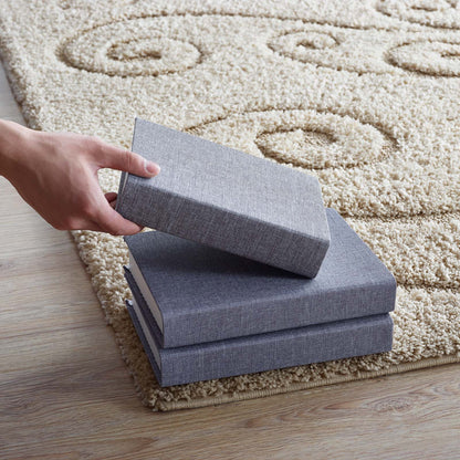Cream and beige shag area rug with a scrolling vine pattern.