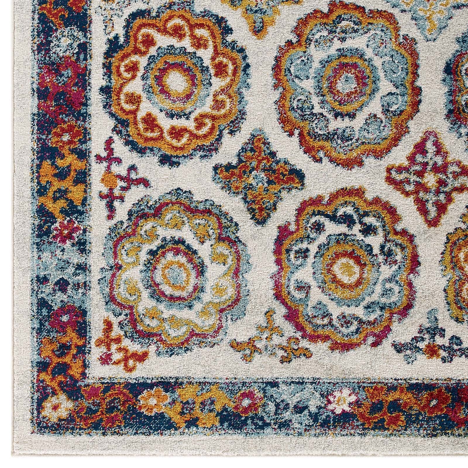 Area rug corner with ivory field and ornate multicolor floral medallions in blue, gold, red; blue border.