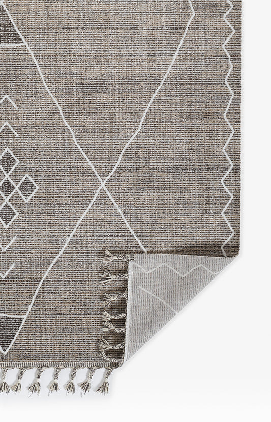Gray woven rug with white geometric lines, diamond shapes and a zigzag border; fringe tassels along one edge, folded corner.