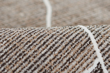Close-up of brown and gray striped woven rug with white piping seam and textured pile