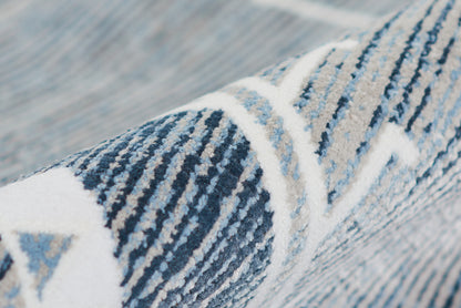 Close-up of a blue and white geometric rug with woven texture and diagonal stripe pattern.