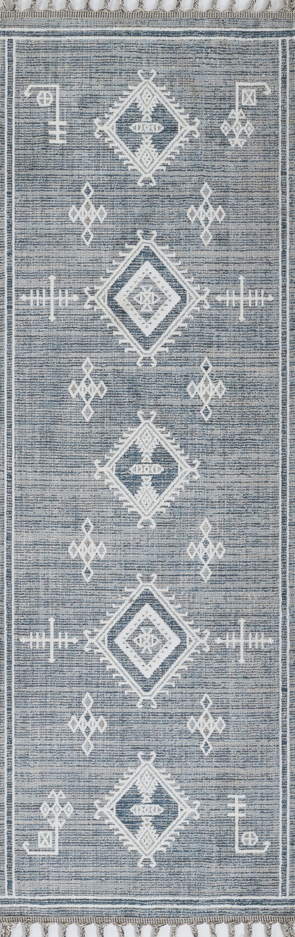 Blue woven rug with white geometric diamond motifs and fringe edge.