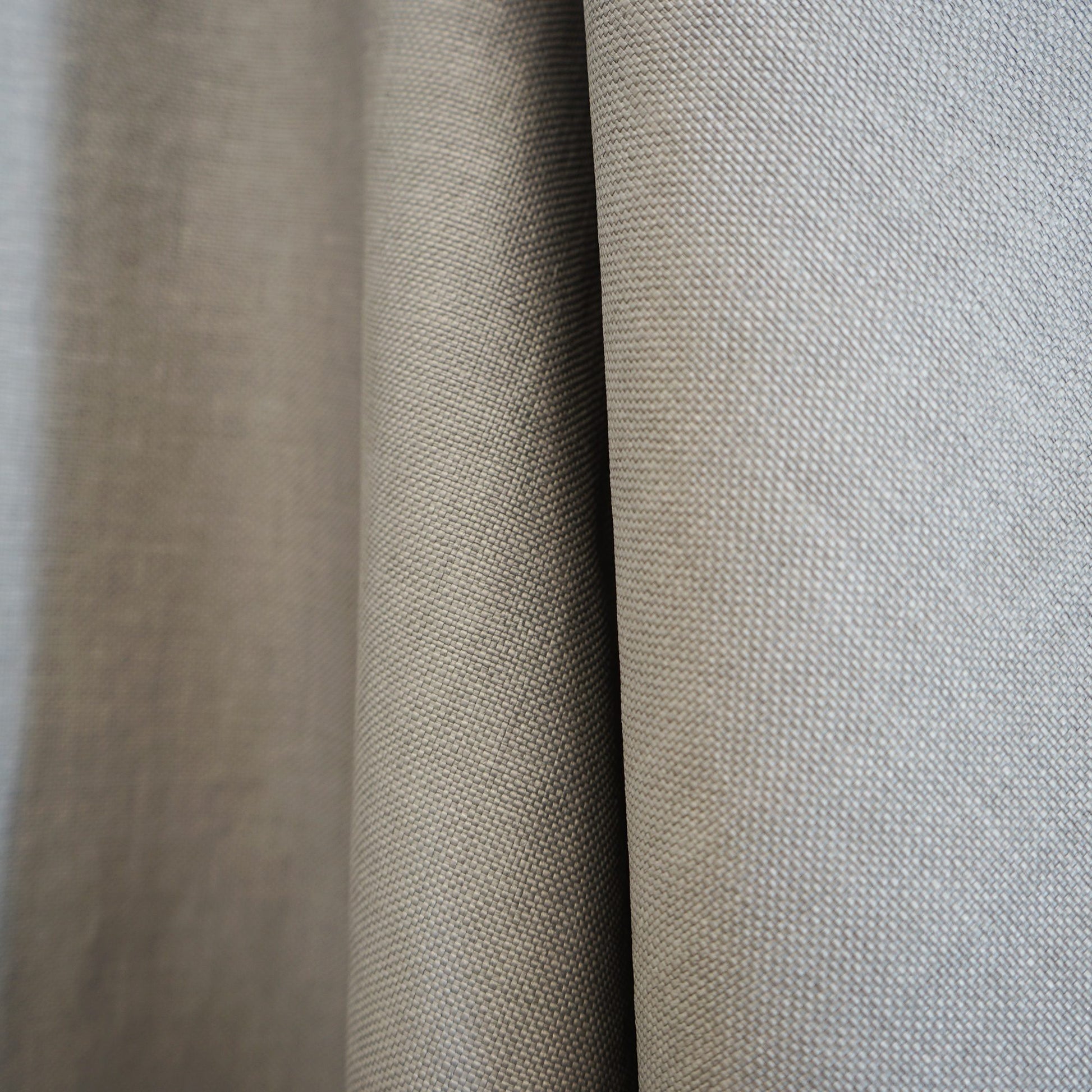 Beige and light gray woven fabric swatches with a textured linen-like weave and draped folds.