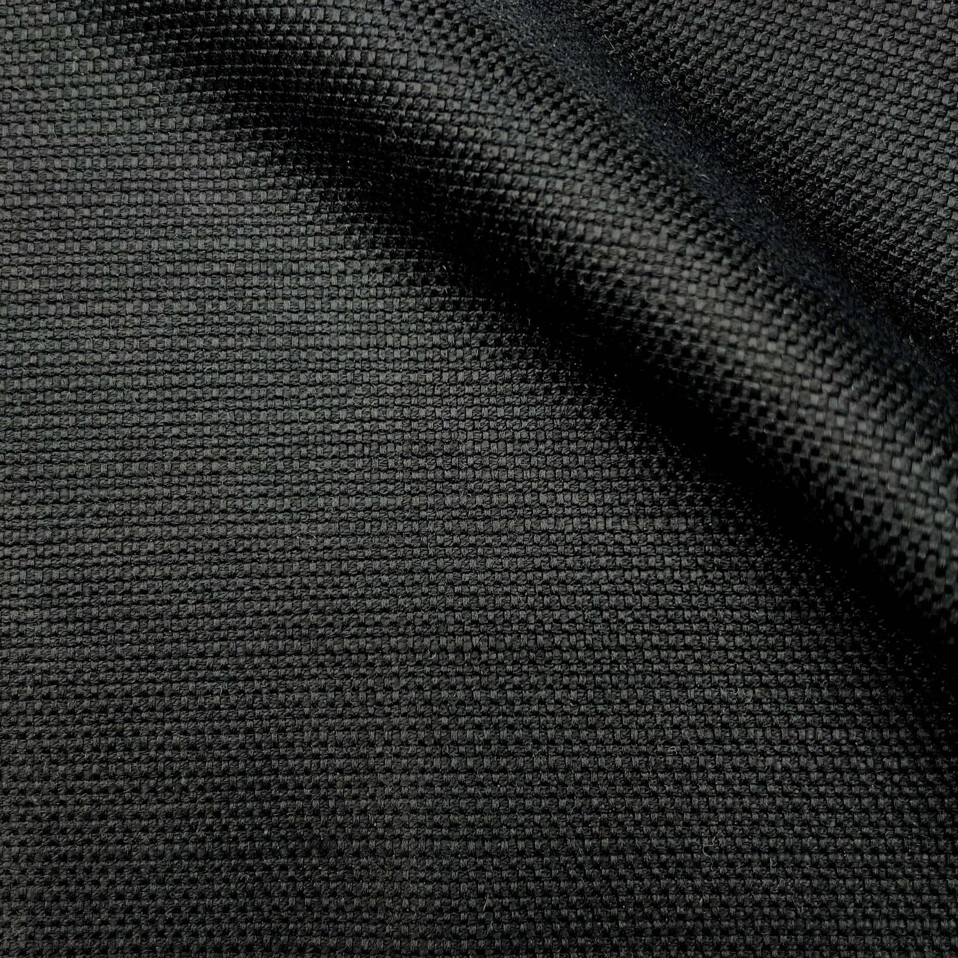 Close-up of black woven fabric with tight texture and a diagonal fold.