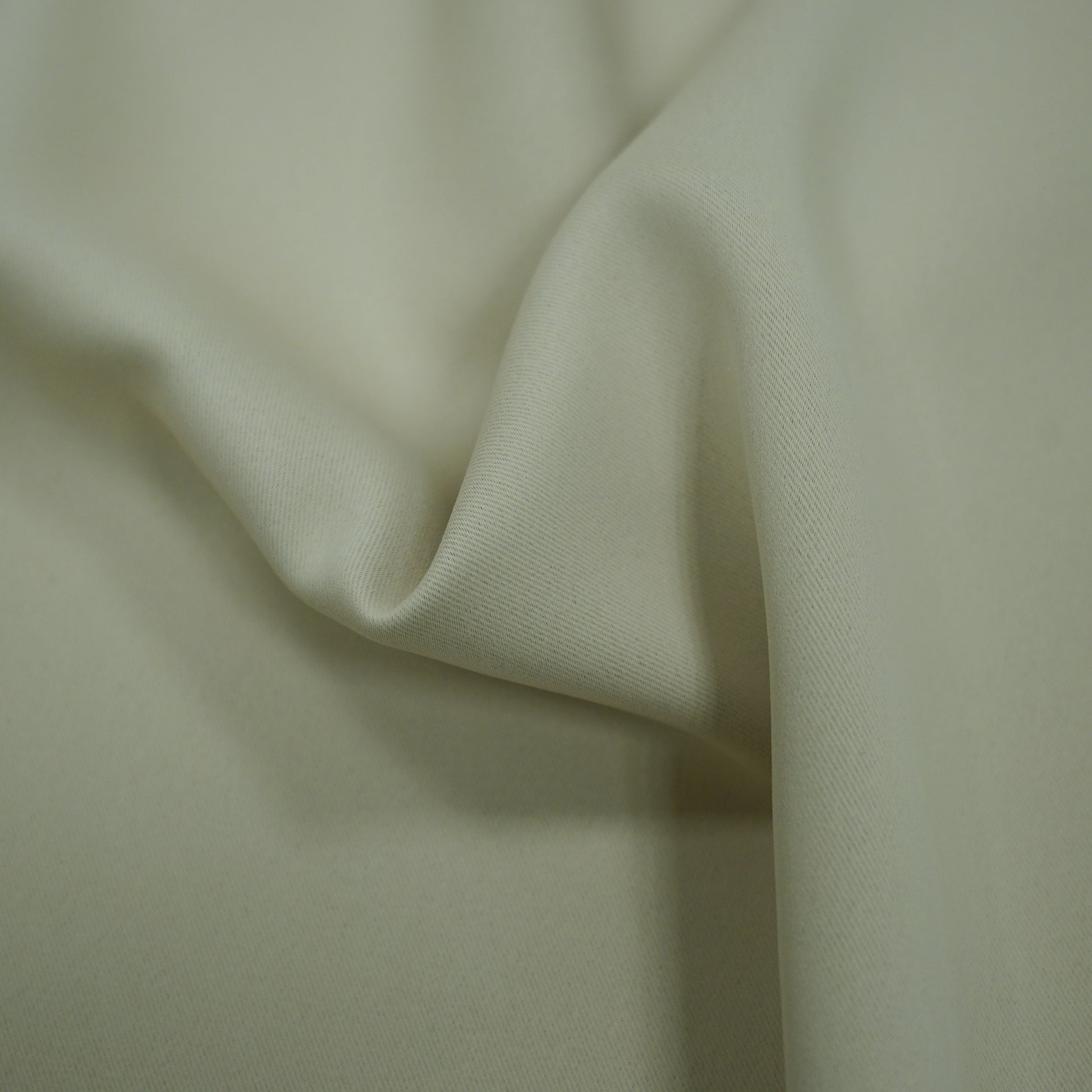 Cream fabric with gentle drape and soft folds, smooth texture.